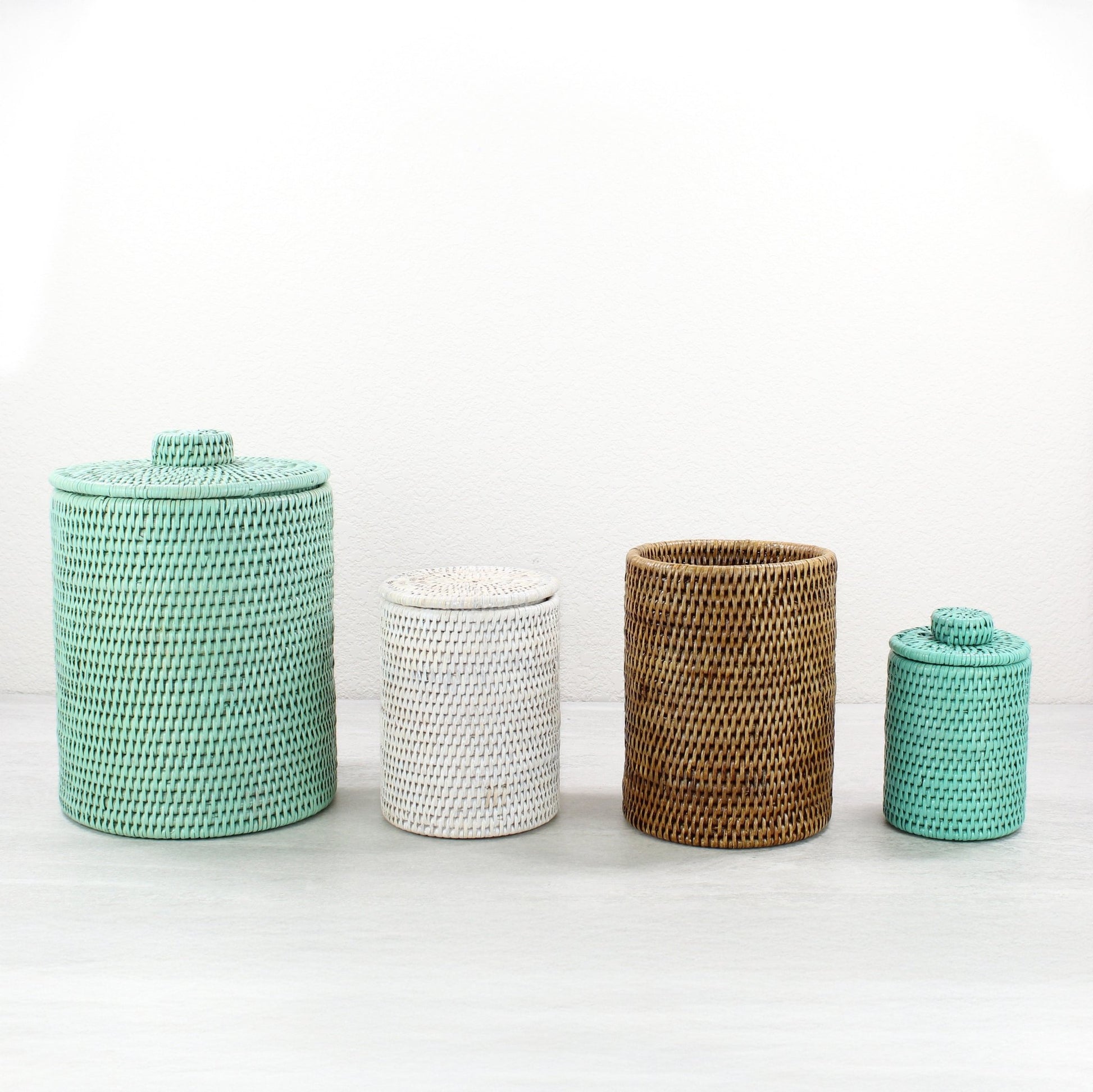 Eco Handcraft set of 4 handmade rattan canisters in sage green, whitewash, honey brown, and turquoise on white backdrop