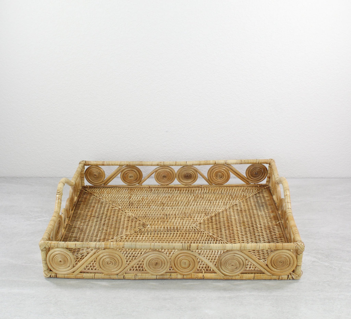 Natural rectangular rattan tray with swirl edge design, handmade for serving, organizing, or modern home décor styling, front view.