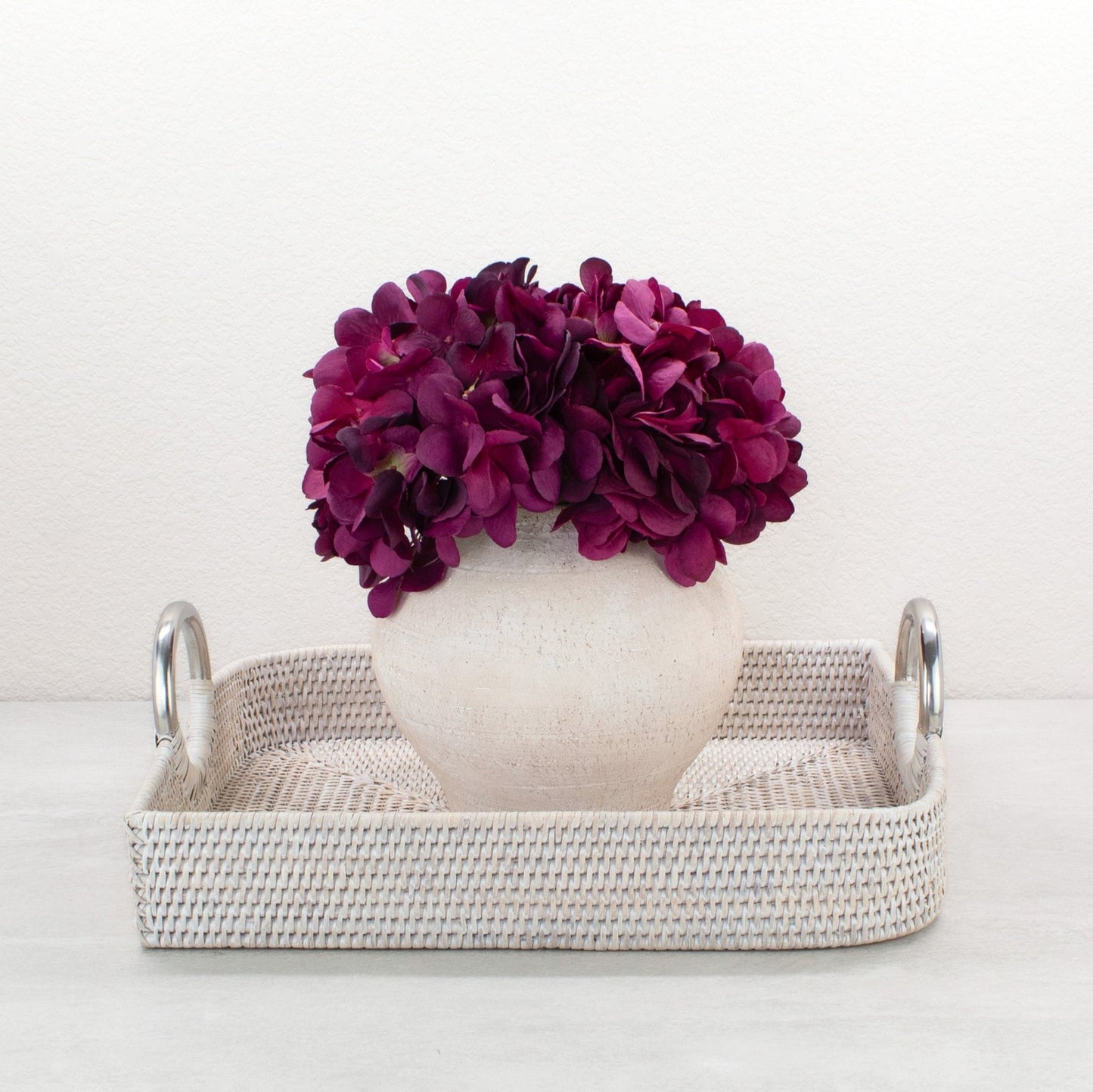 Eco Handcraft small whitewash rattan tray with steel handles styled with purple hydrangea in ceramic vase as elegant table centerpiece