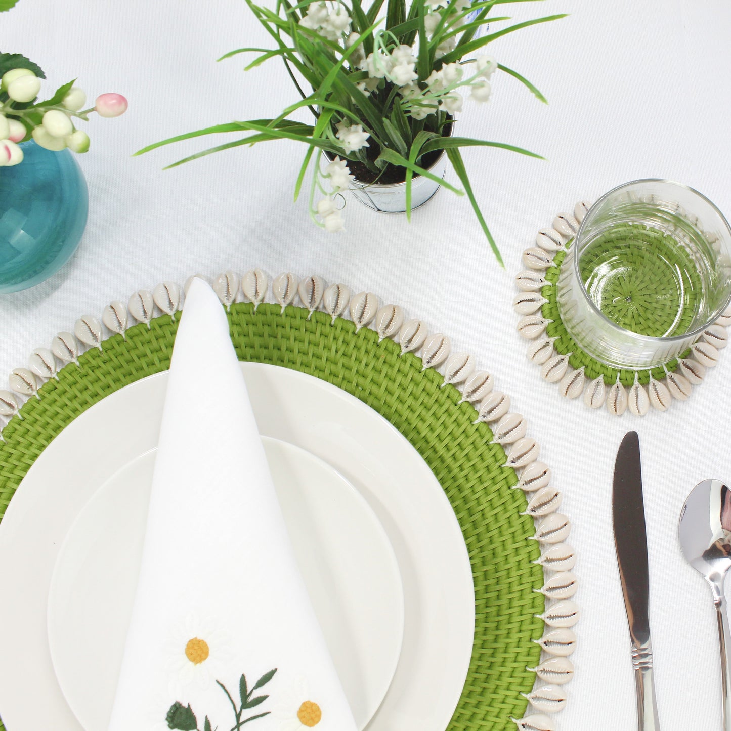 Lime Green rattan coaster with seashell trim styled on a dining table with glassware and matching seashell placemat for an elegant coastal-inspired tablescape