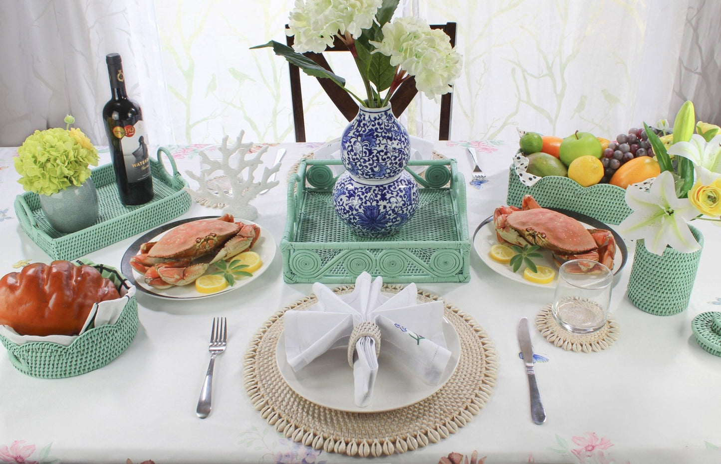 Elegant coastal dining setup with Eco Handcraft rattan trays, coasters, napkin rings, and seafood display