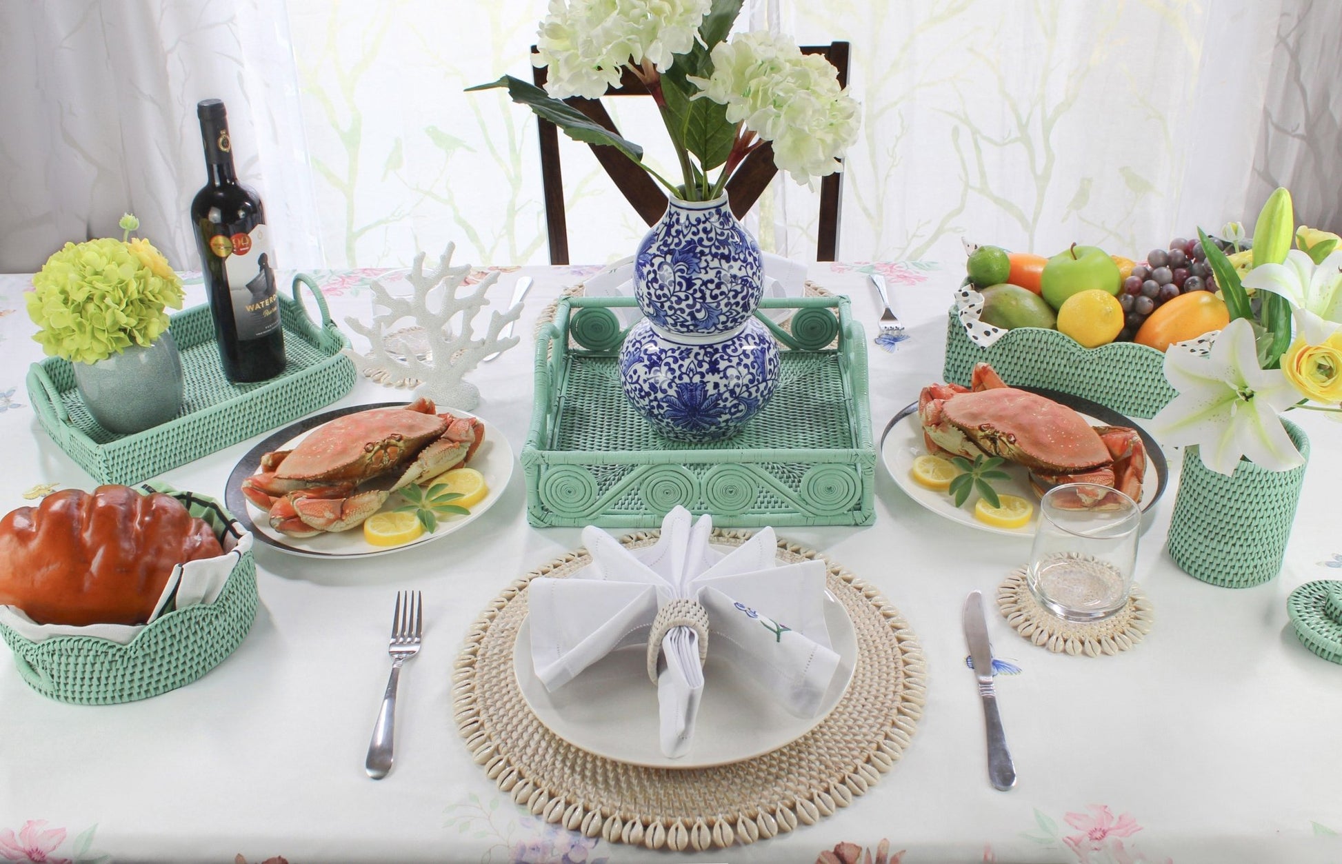 Elegant coastal dining setup with Eco Handcraft rattan trays, coasters, napkin rings, and seafood display