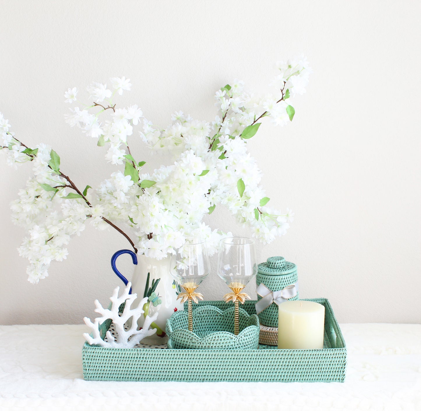 Wedding gift set featuring sage leaf green rattan tray, round scalloped tray, canister with lid, seashell coasters, and floral accents