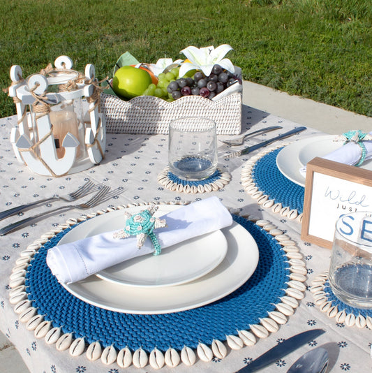 Eco Handcraft shell-trimmed placemats and rattan fruit basket – handmade coastal dining with fresh, beachy elegance