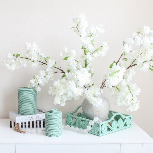 Eco Handcraft sage green rattan decor with white blossoms – handmade tray and canisters for elegant spring styling
