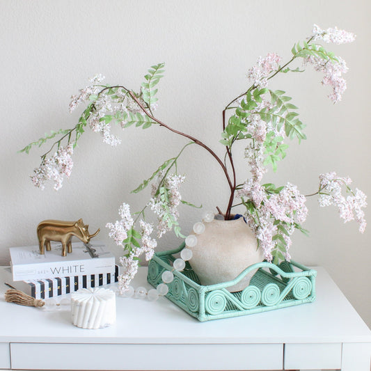 Eco Handcraft sage green rattan tray styled with soft pink florals – handmade, natural elegance for modern interiors
