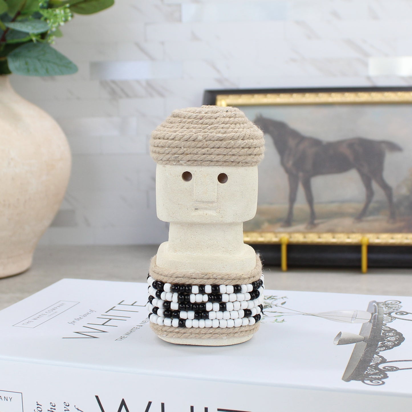 Handcrafted Sumba statue with jute rope cap and black-and-white beaded skirt - artisan tribal home accent.