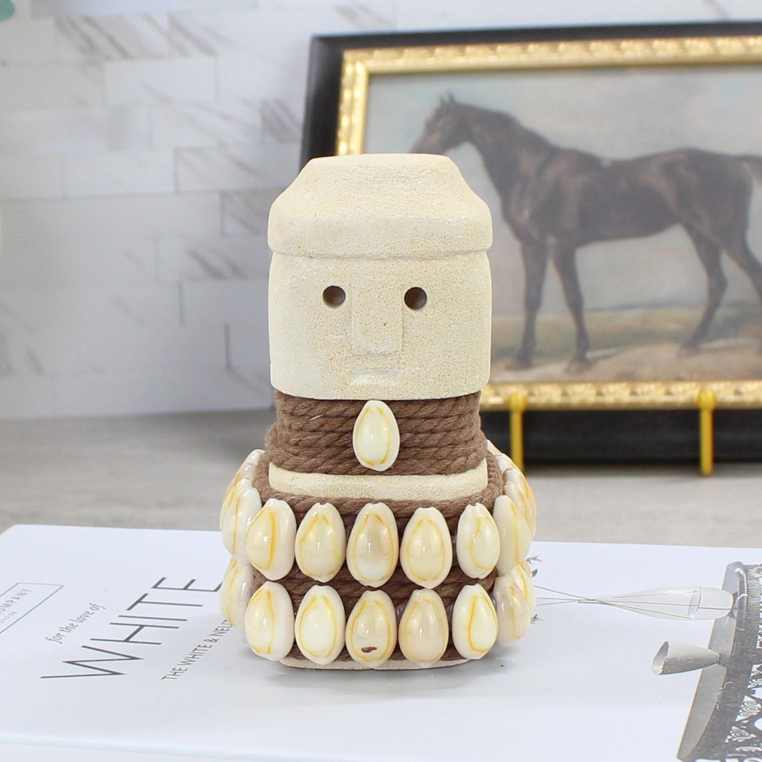 Sumba guardian statue with rounded head and cowrie shell skirt - handmade Indonesian stone figurine.