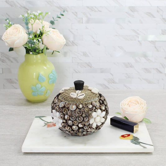 Artisan-crafted seashell storage boxes in small, medium, and large sizes, featuring cowrie shell accents and rope lid, styled with flowers.