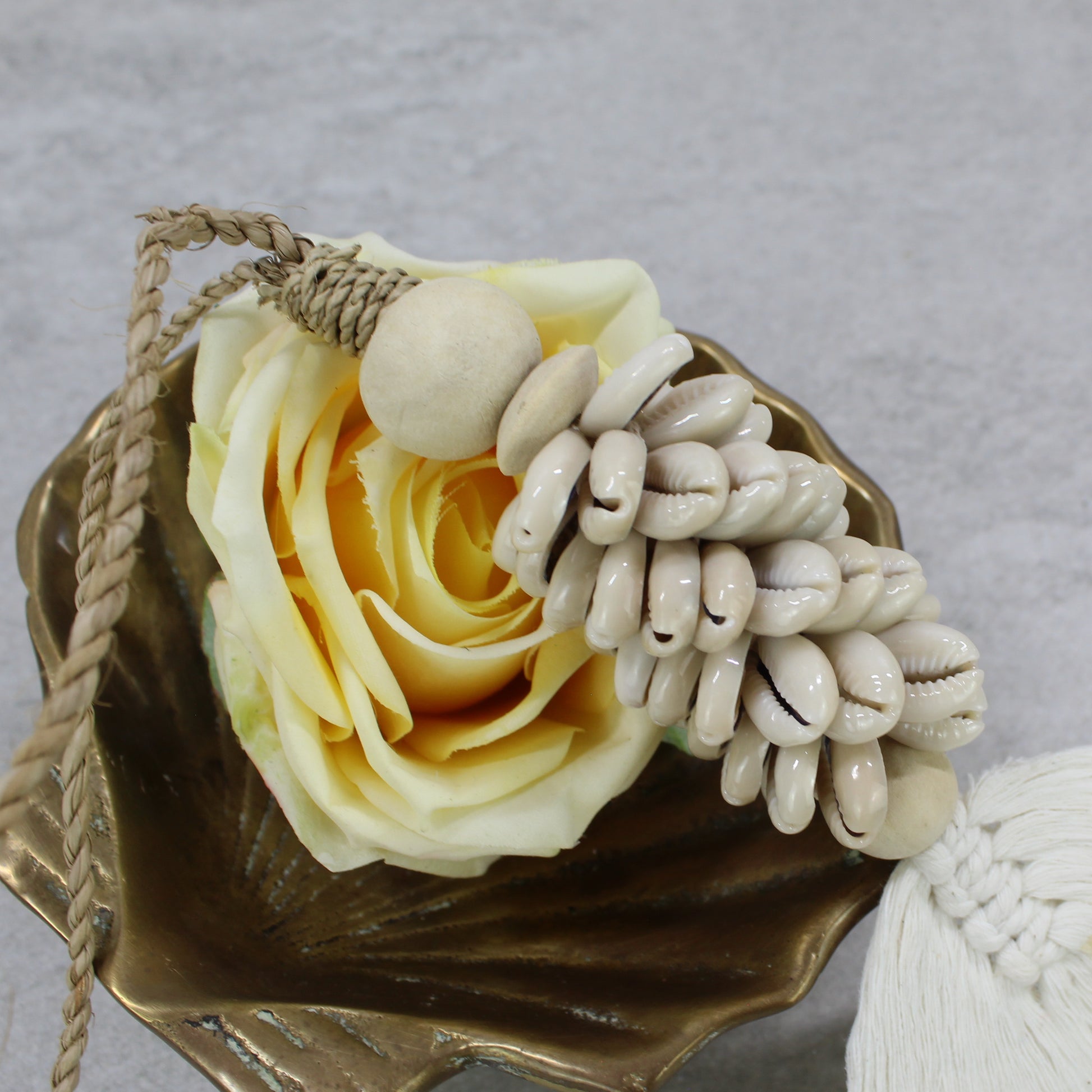 Close-up of beige cowrie shell cluster tassel with macramé cotton leaf detail handmade by Eco Handcraft