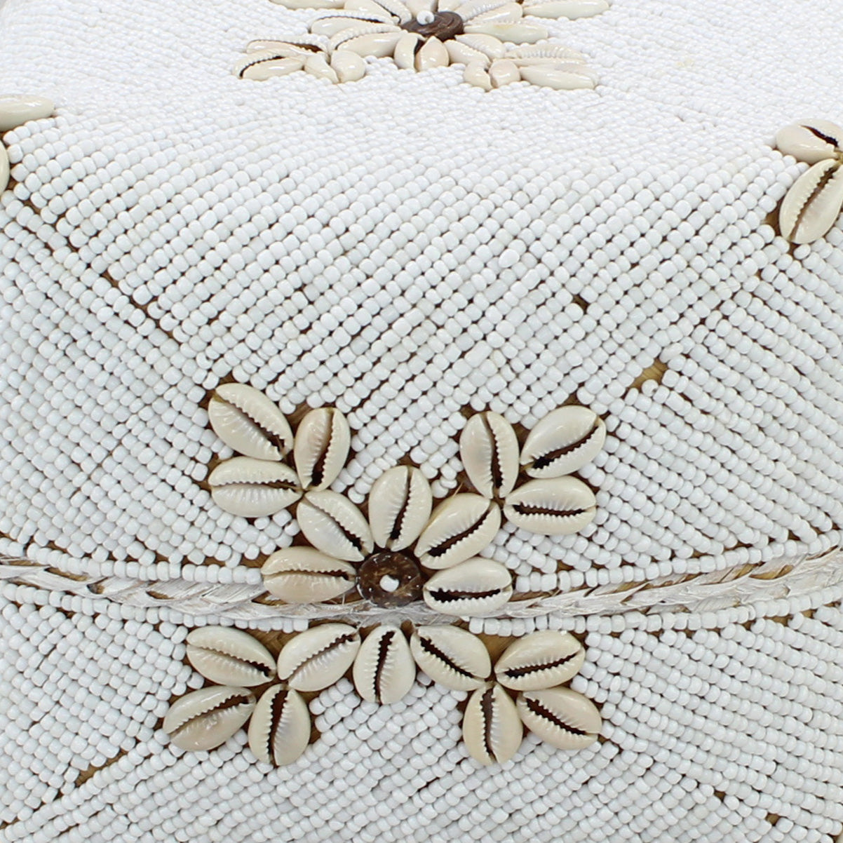 Close-up of handmade white beaded decorative box with natural cowrie shell flower design and fine bead detailing.