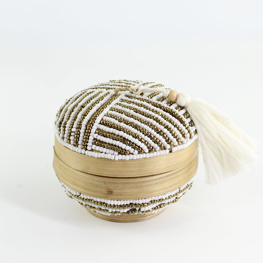 Handmade white and gold linear beaded round bamboo tassel box styled with roses on a gray table