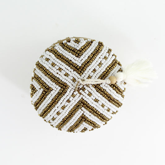 Top view of handmade white and gold chevron beaded bamboo tassel box highlighting intricate beadwork and artisan craftsmanship.