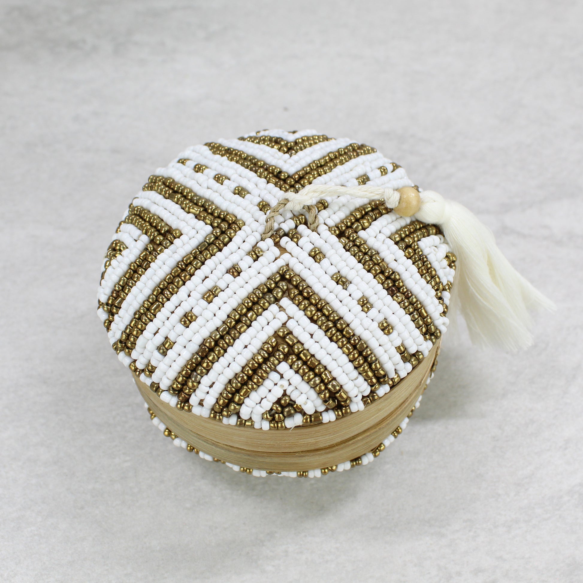 Eco Handcraft chevron-patterned white and gold beaded bamboo tassel box styled with yellow roses for elegant boho home décor.