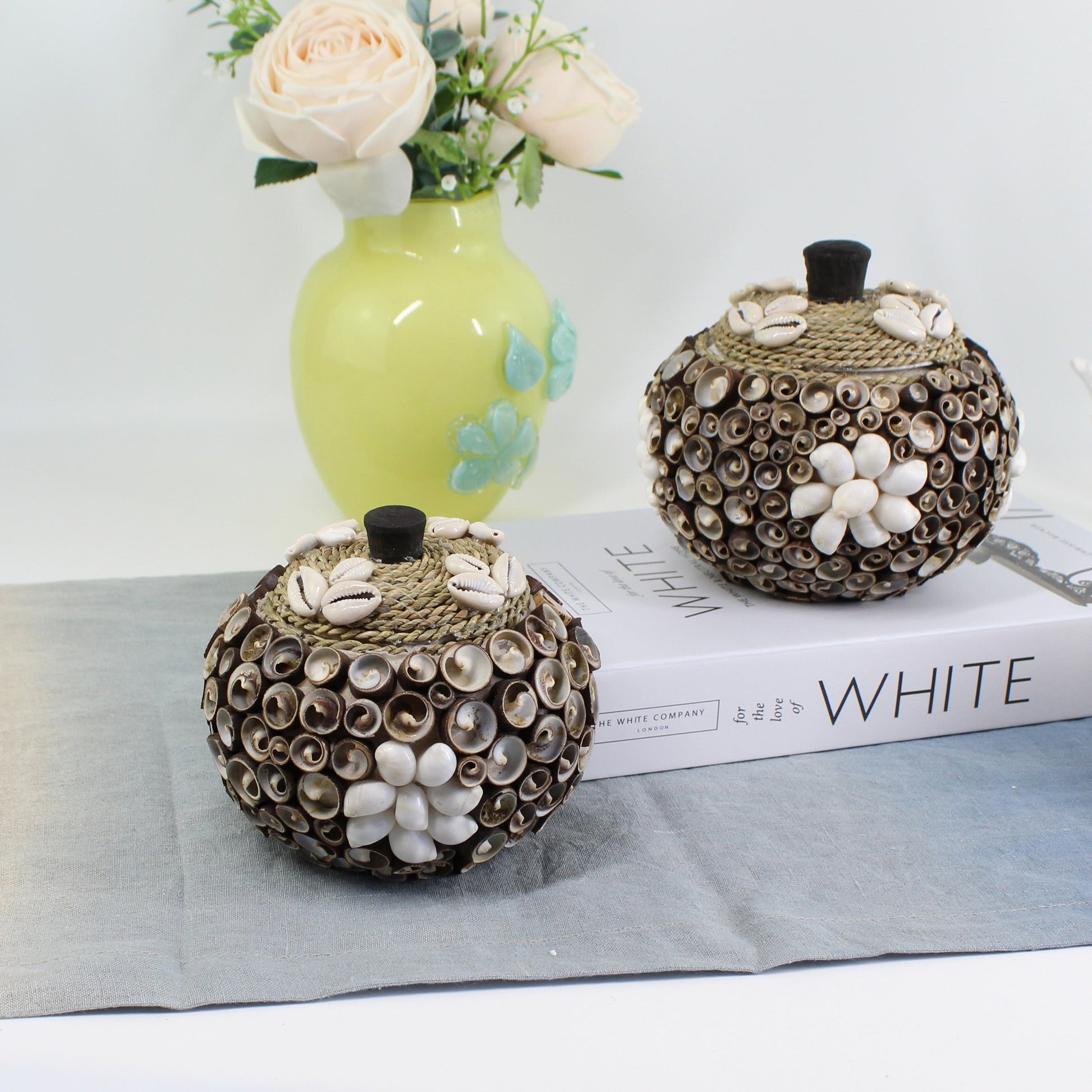 Medium handmade seashell storage box with cowrie and spiral shells, artisan coastal décor accent for jewelry and trinket storage.