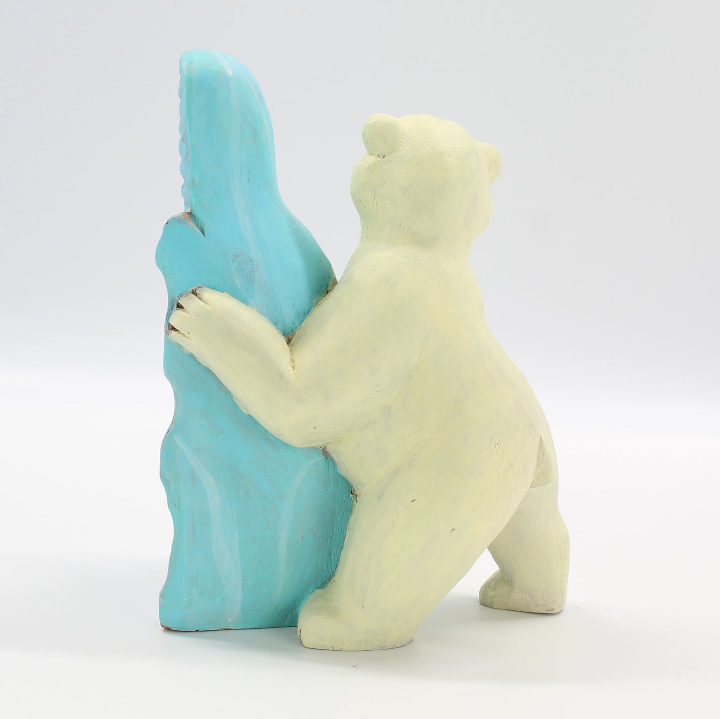 Back view of Eco Handcraft polar bear wood sculpture with blue ice block, artisanal eco-conscious décor piece.