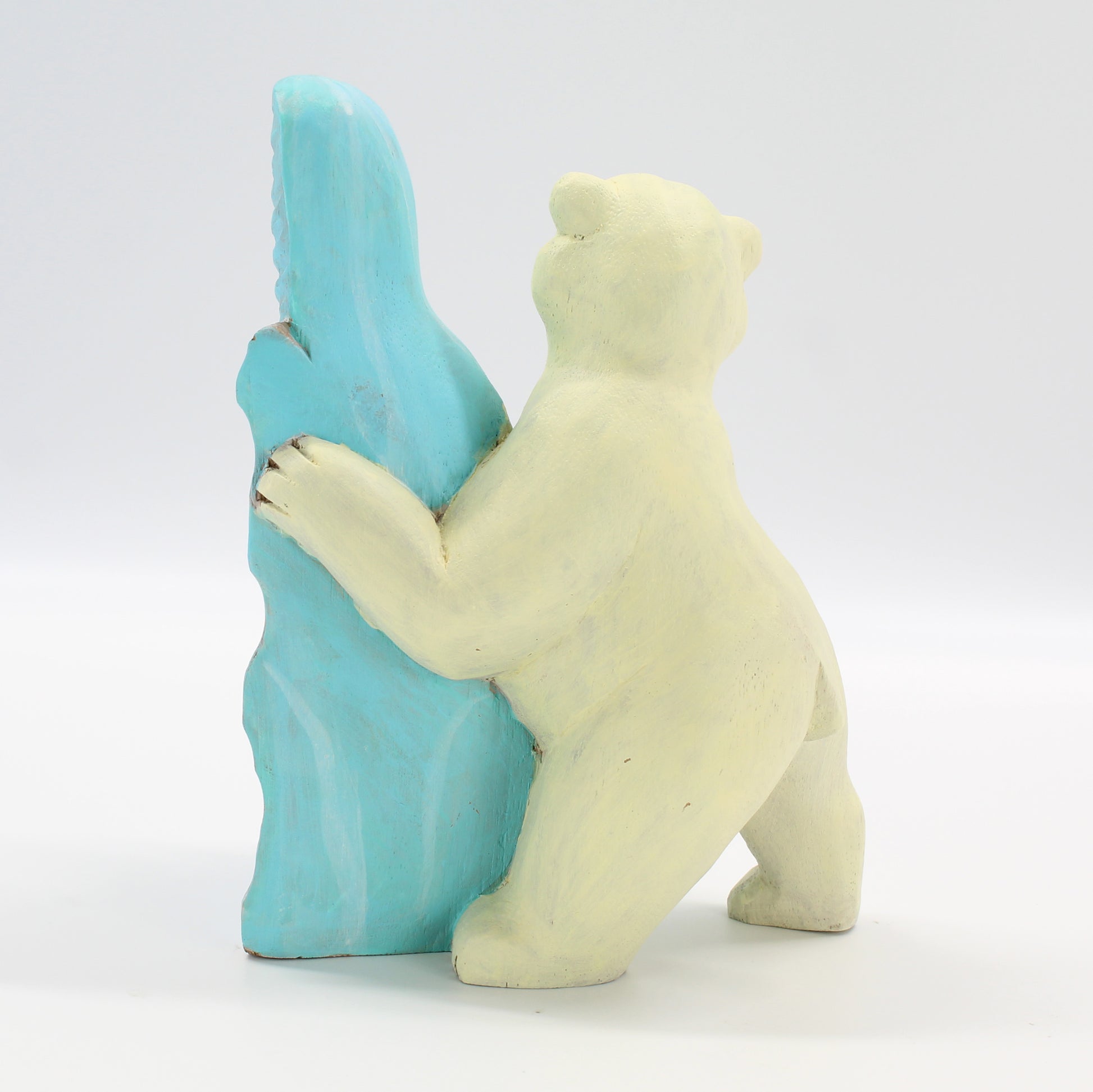 Back view of Eco Handcraft polar bear wood sculpture with blue ice block, artisanal eco-conscious décor piece.