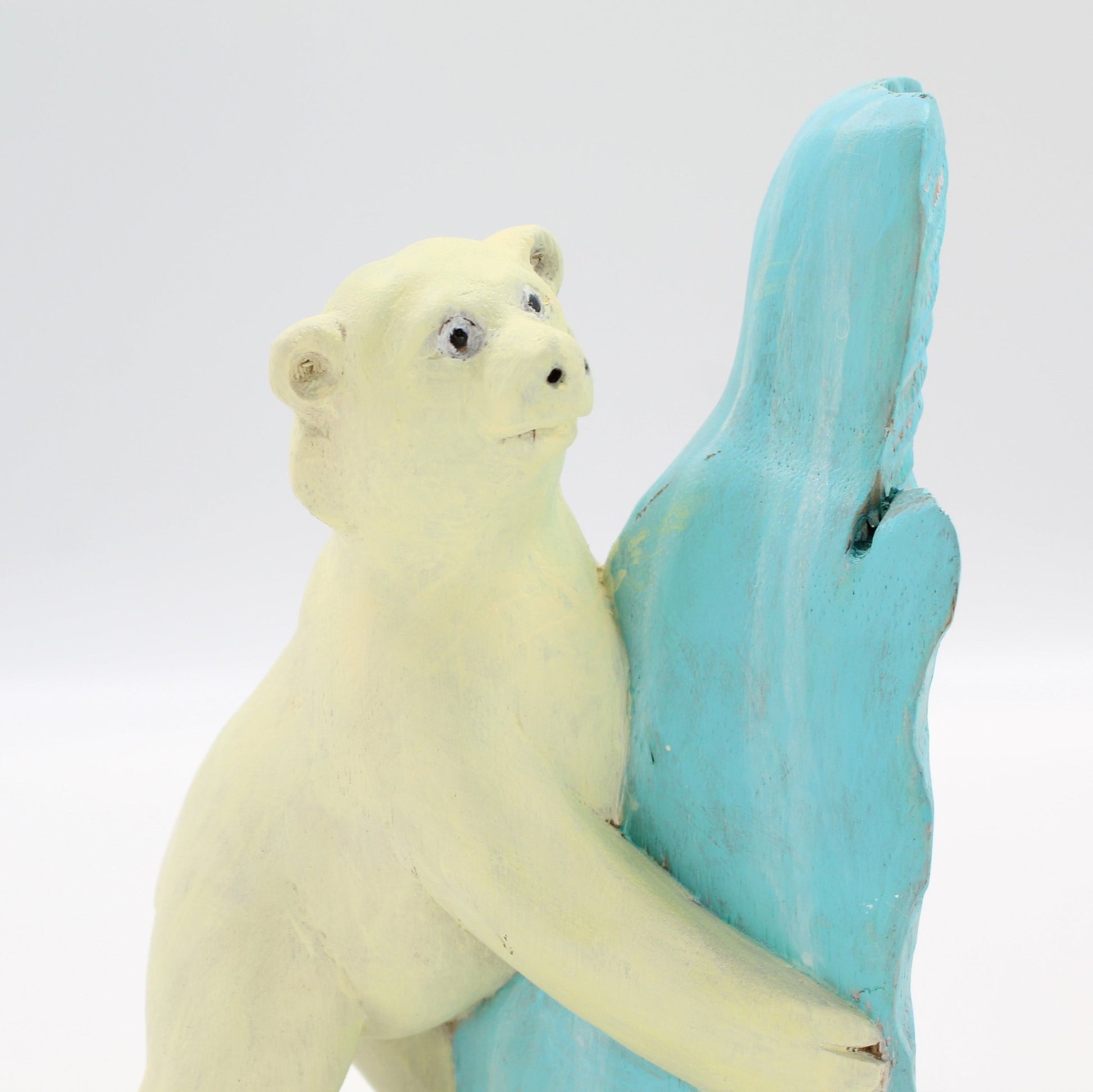 Eco-conscious hand-painted polar bear wood sculpture hugging a blue ice-shaped block, sustainable holiday home décor figurine.