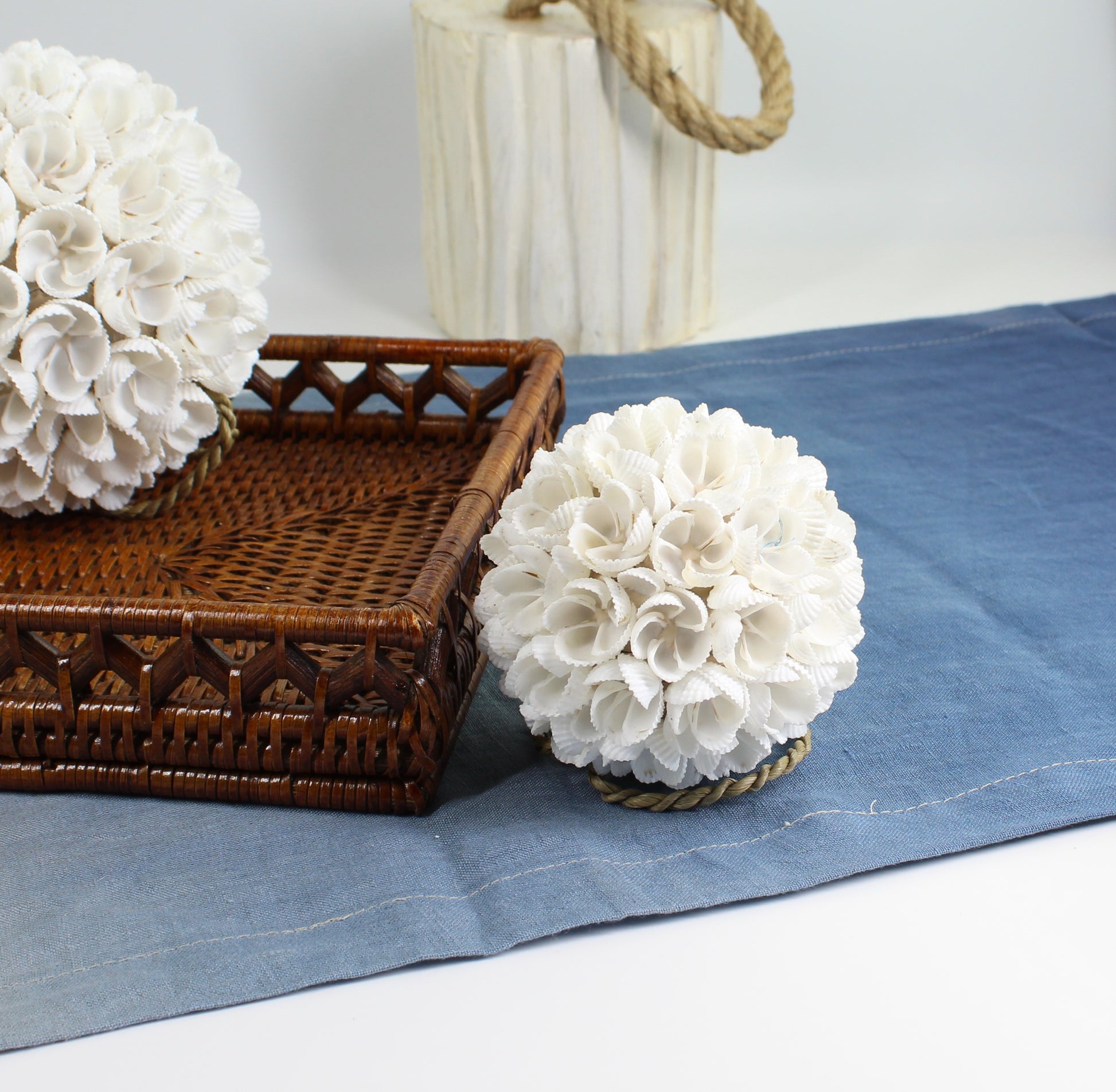 Small seashell blossom ball ornament with rope loop handcrafted from natural white shells, designed for coastal tray styling or decorative bowls.