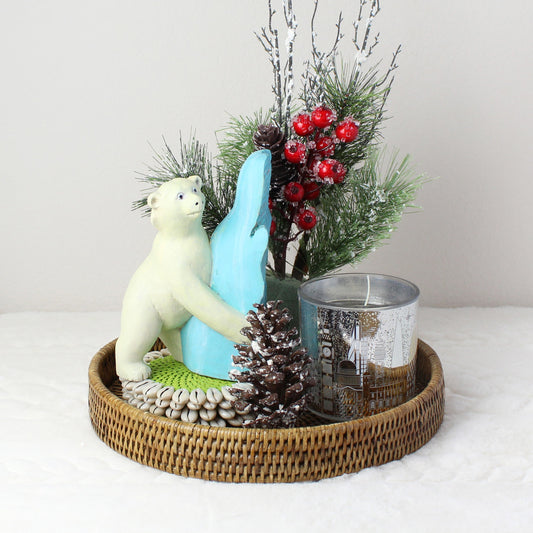 Eco Handcraft holiday gift set featuring a hand-painted polar bear wood sculpture on a honey brown rattan tray with pinecones, berries, and candle decor.