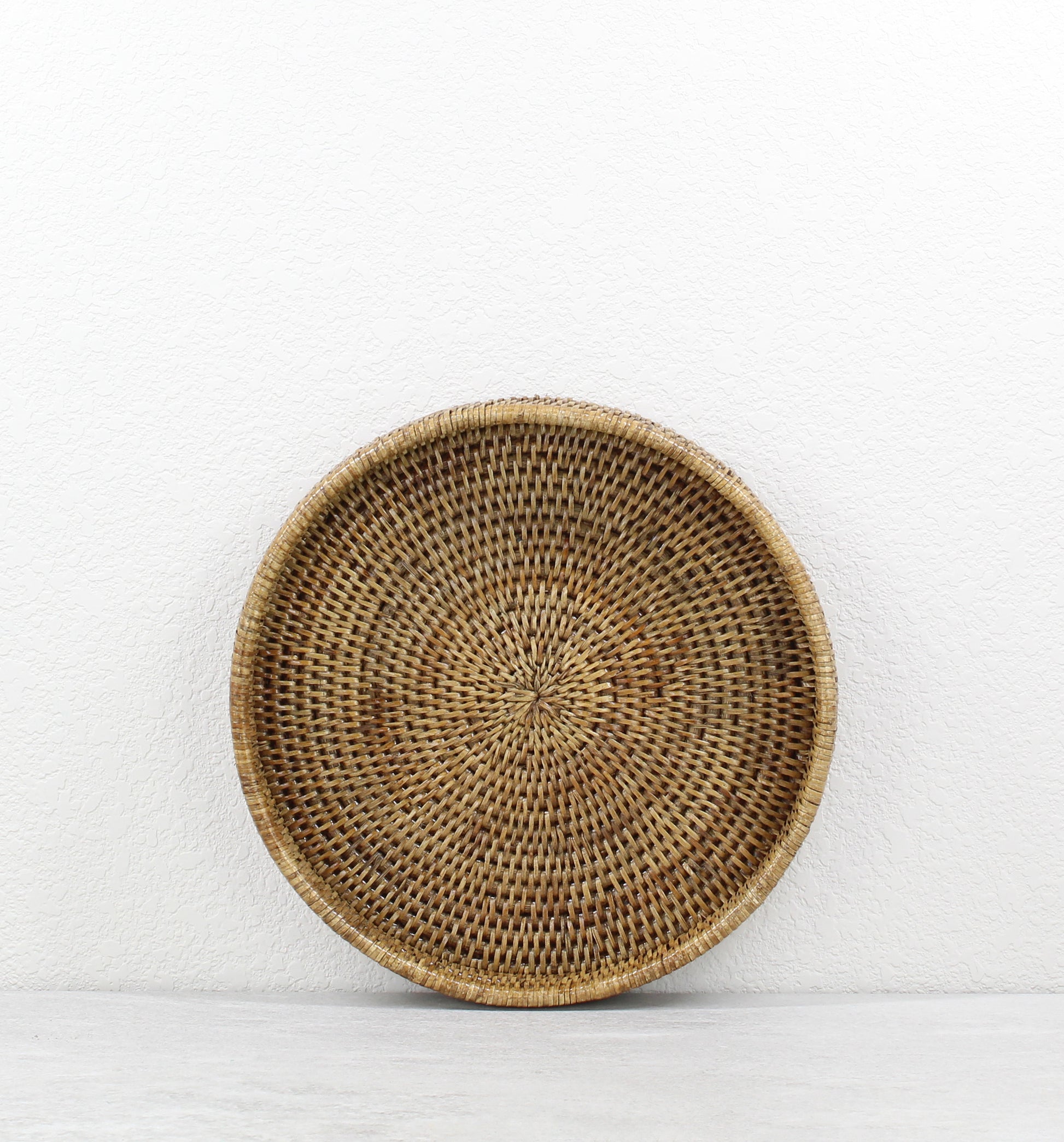 Eco Handcraft small honey brown round rattan tray, tightly woven artisanal design, sustainable décor piece for serving or organizing.