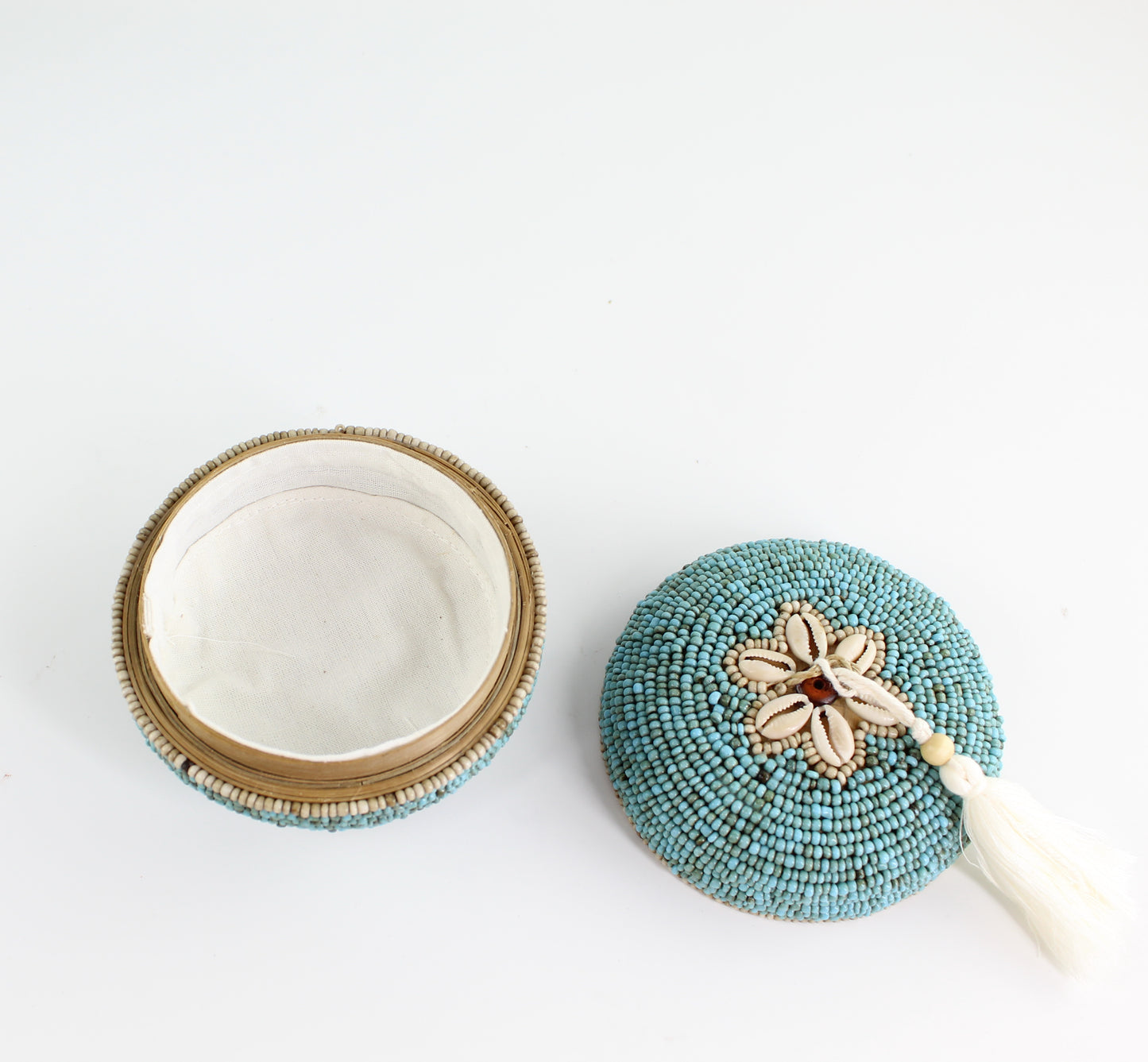 Inside view of turquoise beaded seashell jewelry box with cotton lining and removable lid, eco-friendly handmade decor piece.