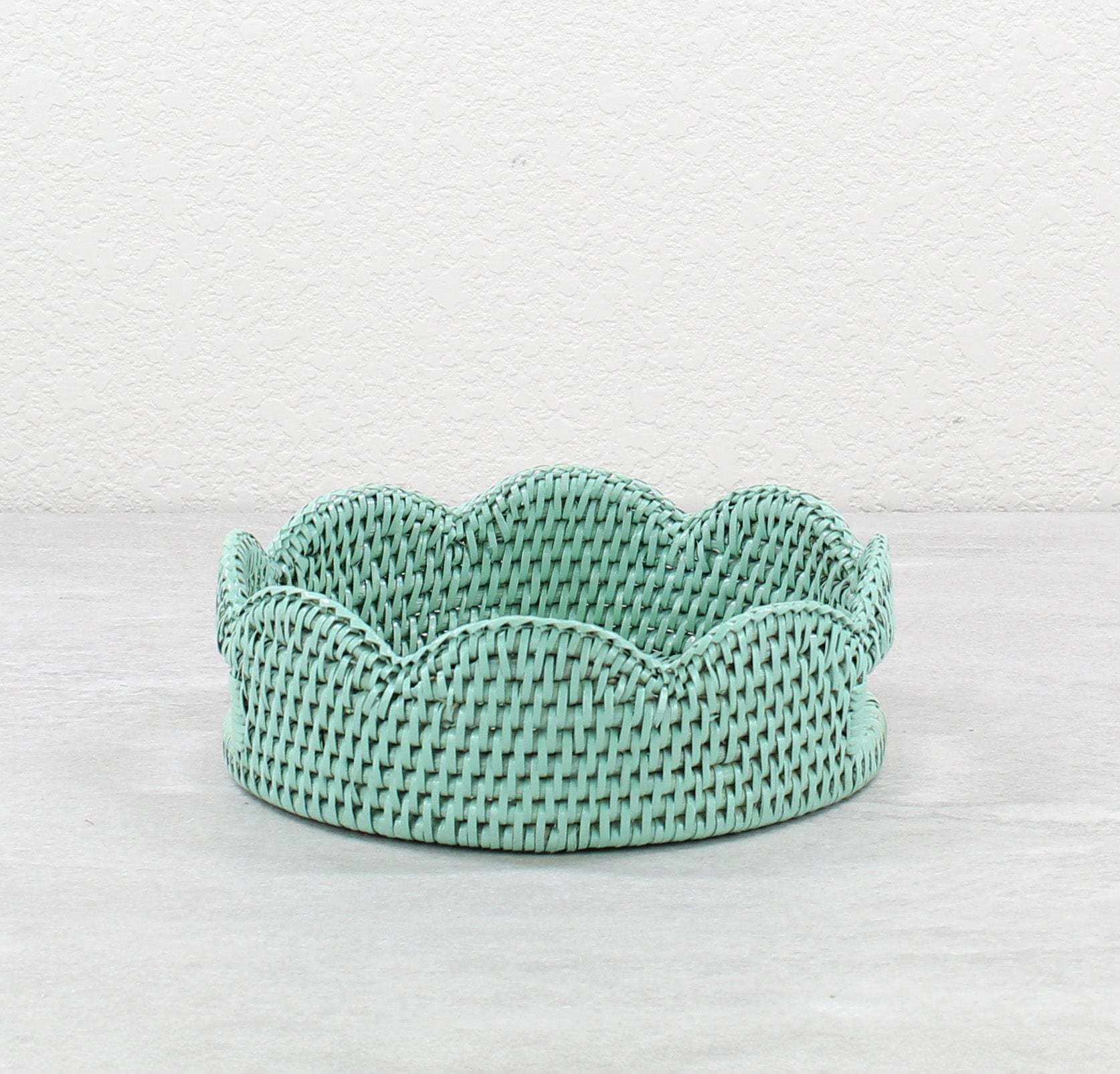 Sage Leaf Green handwoven rattan tray with scalloped edge on a light gray background