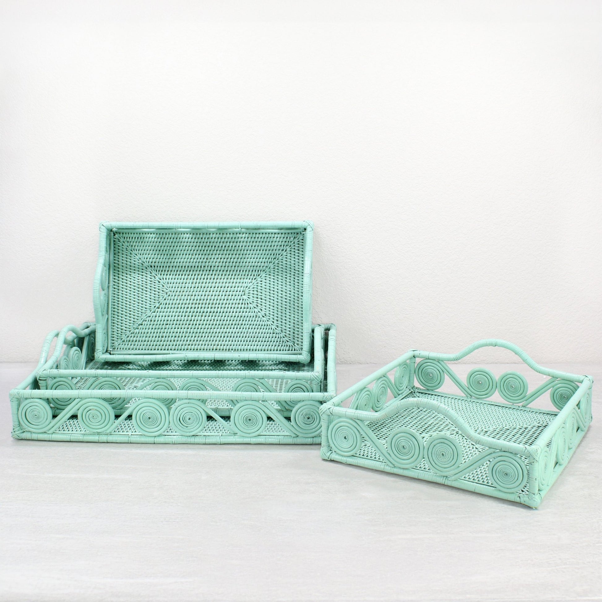 Set of Sage Leaf Green rectangular rattan trays with swirl design, displayed in multiple sizes for luxury mid-century modern home organizing.