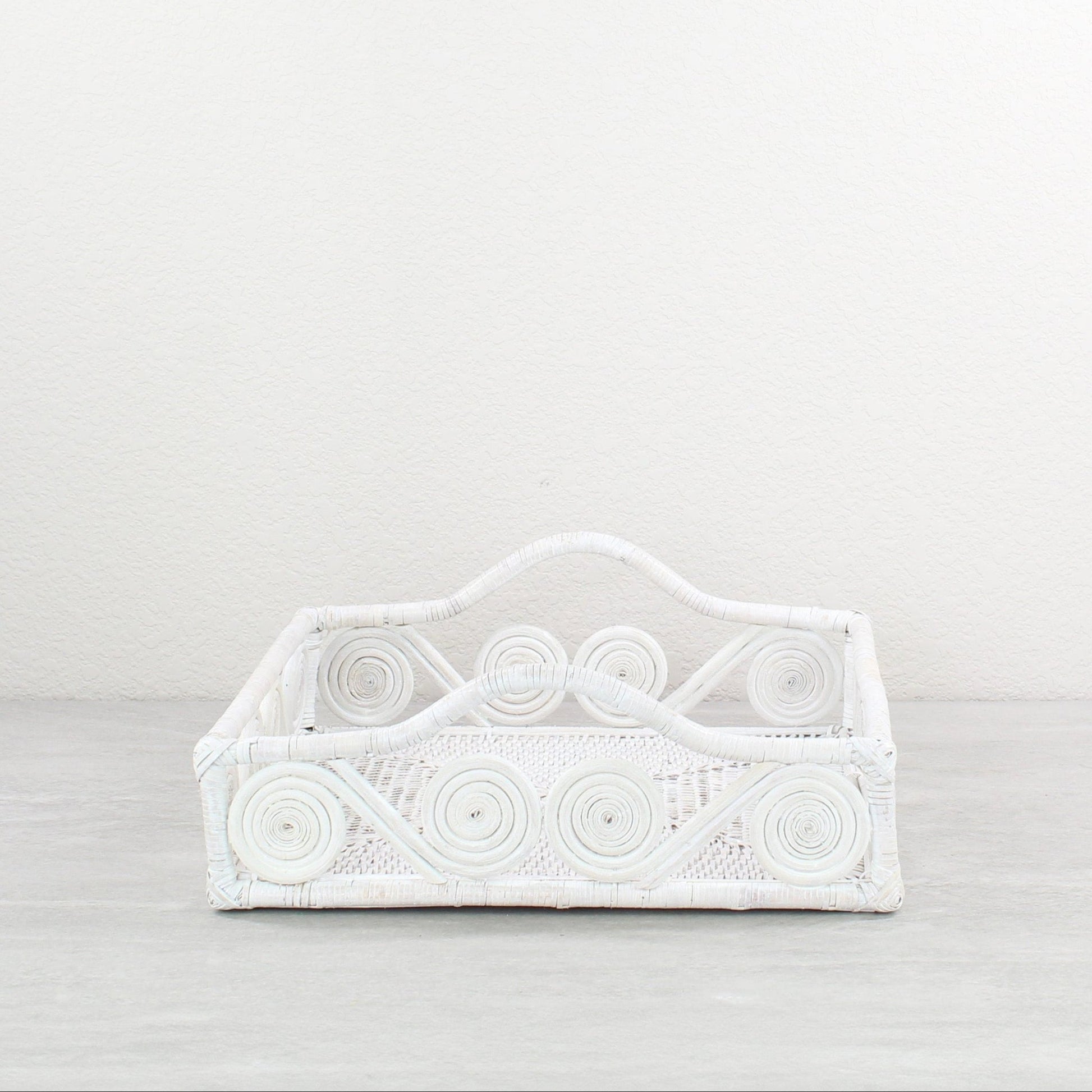 Whitewash decorative swirly rattan tray on a light gray background