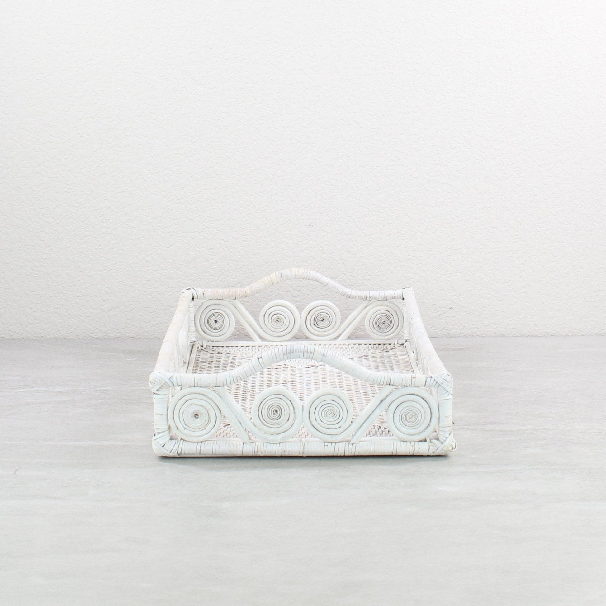 Close-up of swirly woven pattern on whitewash rattan tray, highlighting tight handwoven detail and curved edges.