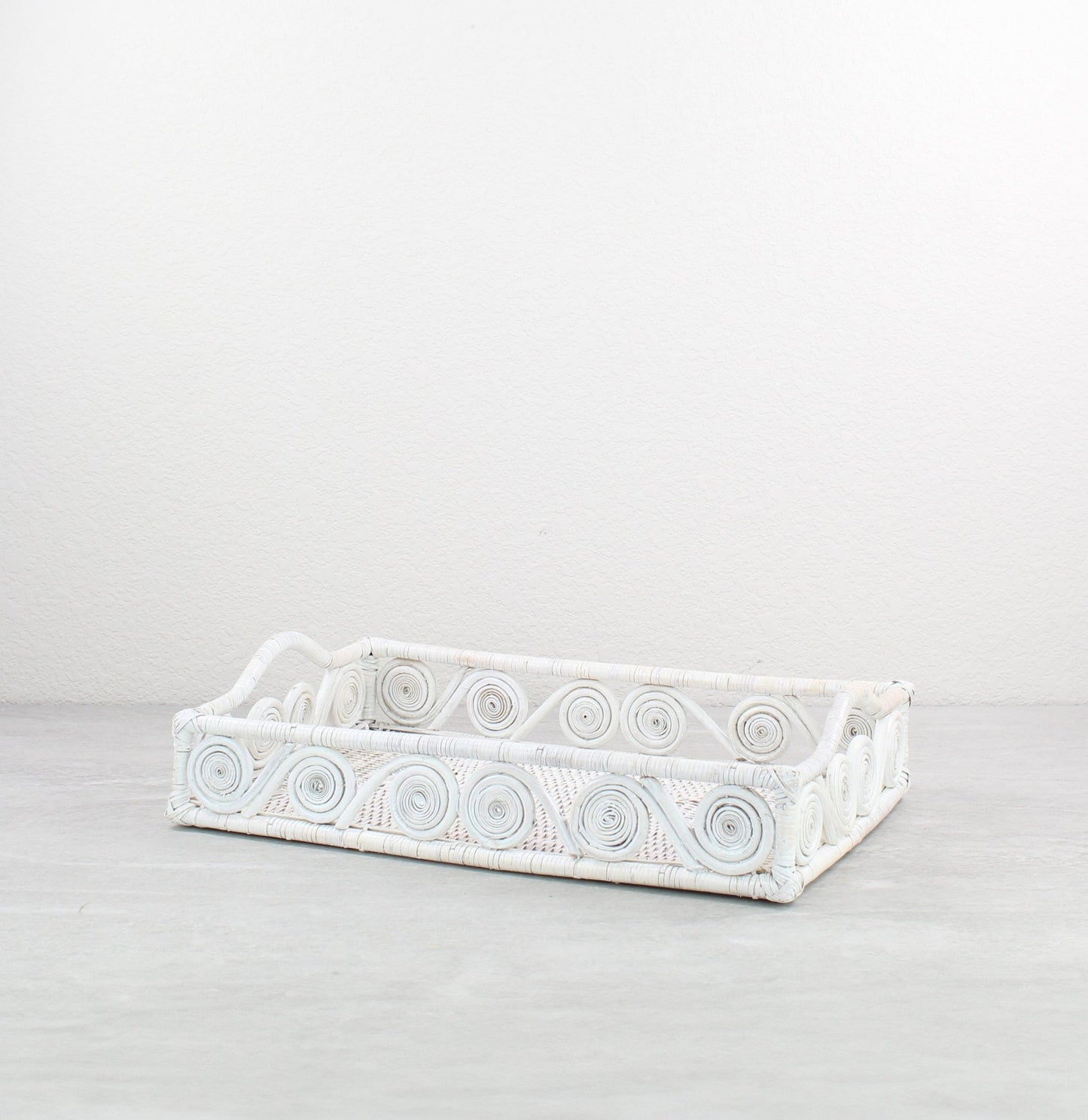 Small swirly rectangle rattan tray in whitewash, tight-woven with handles, shown on white background for product display