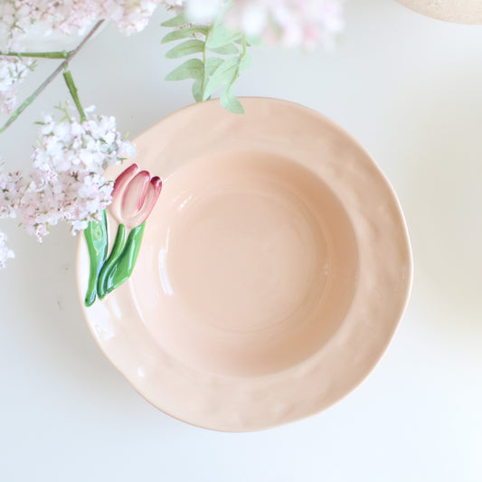 Tulip-themed handpainted stoneware pasta bowl styled on table with pink flowers