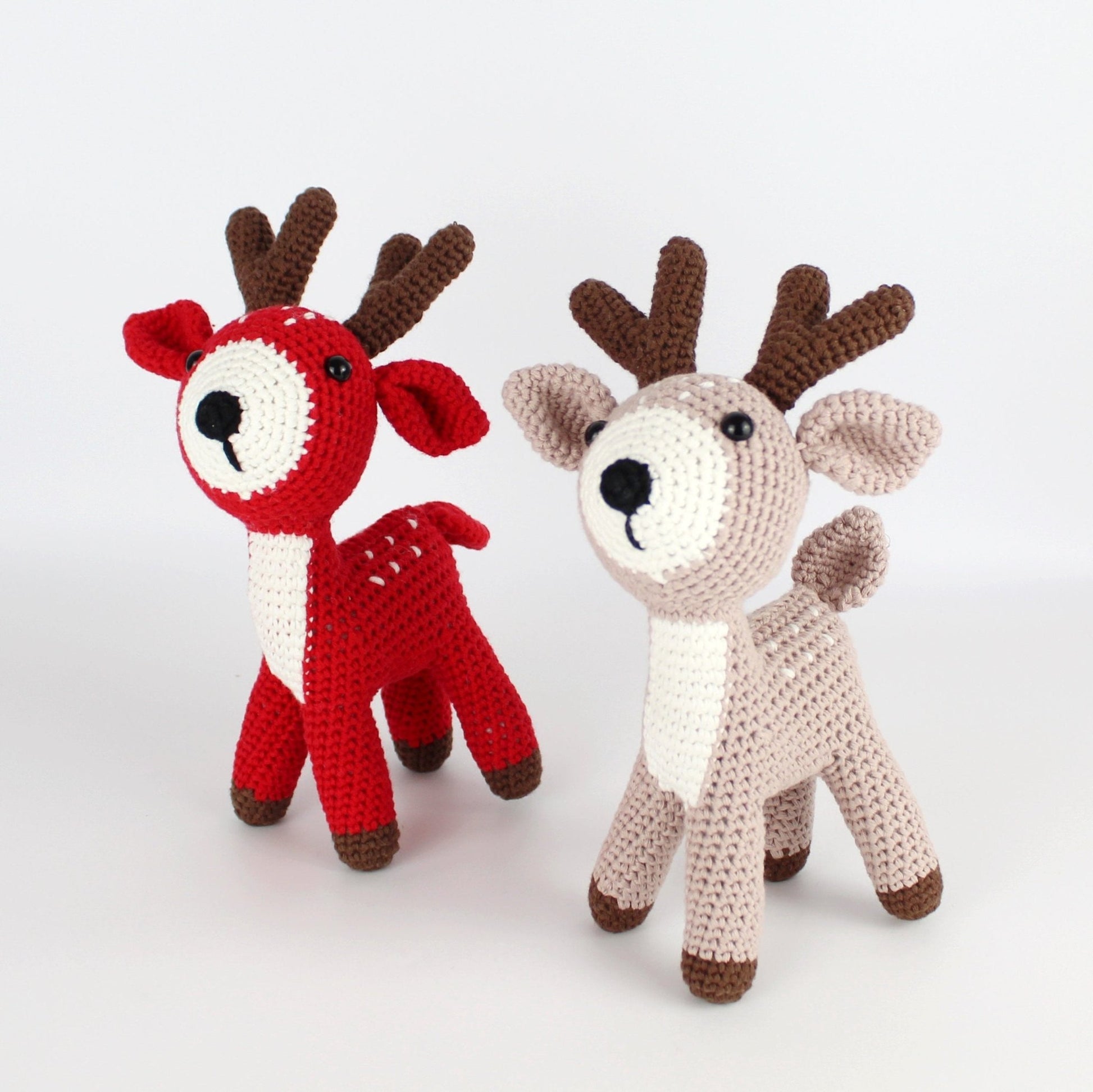 Handmade crochet amigurumi deer pair in red and beige with brown antlers, crafted with eco-friendly yarn for holiday and nursery décor.