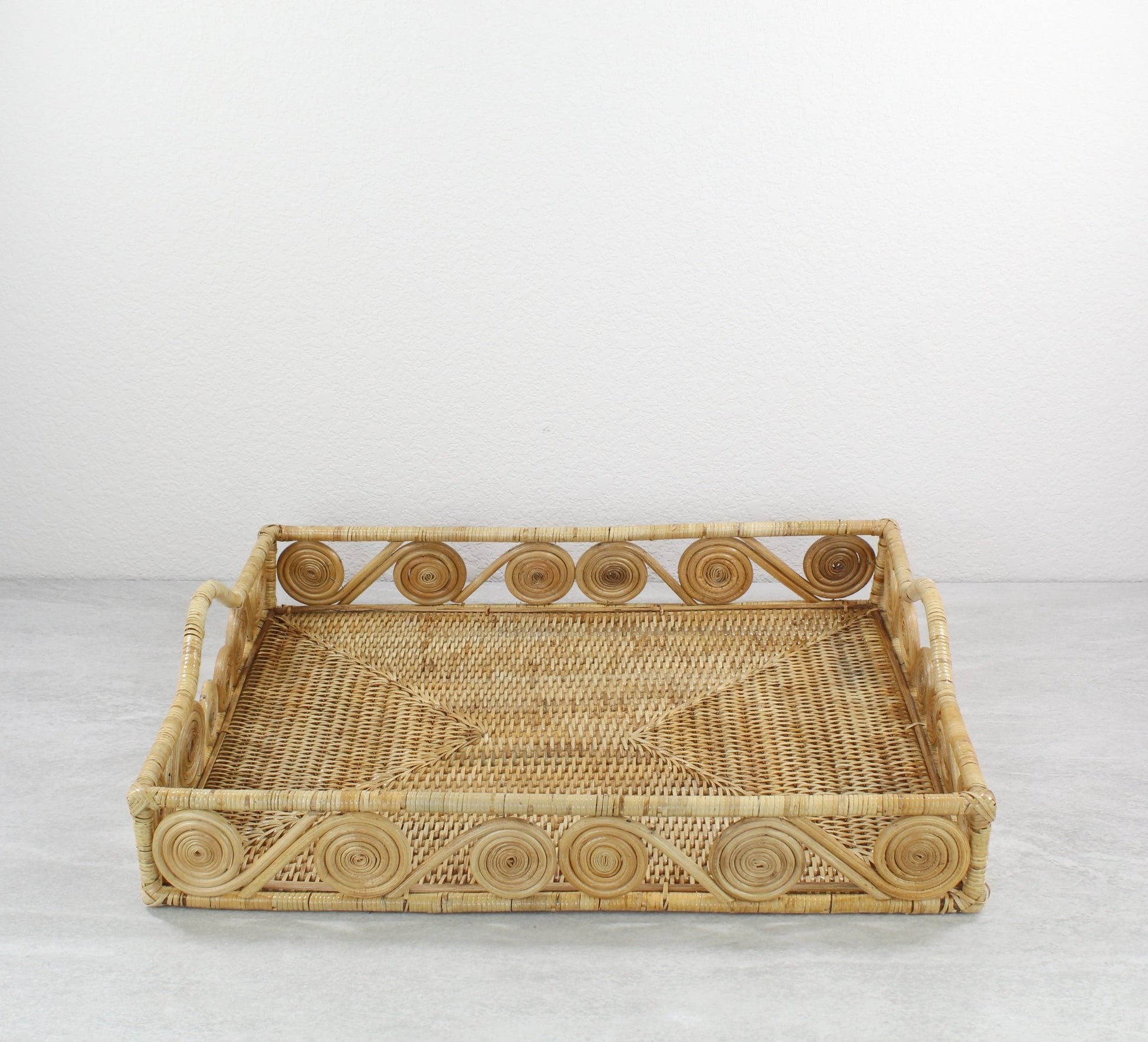 Natural rectangular rattan tray with swirl edge design, handmade for serving, organizing, or modern home décor styling, front view.