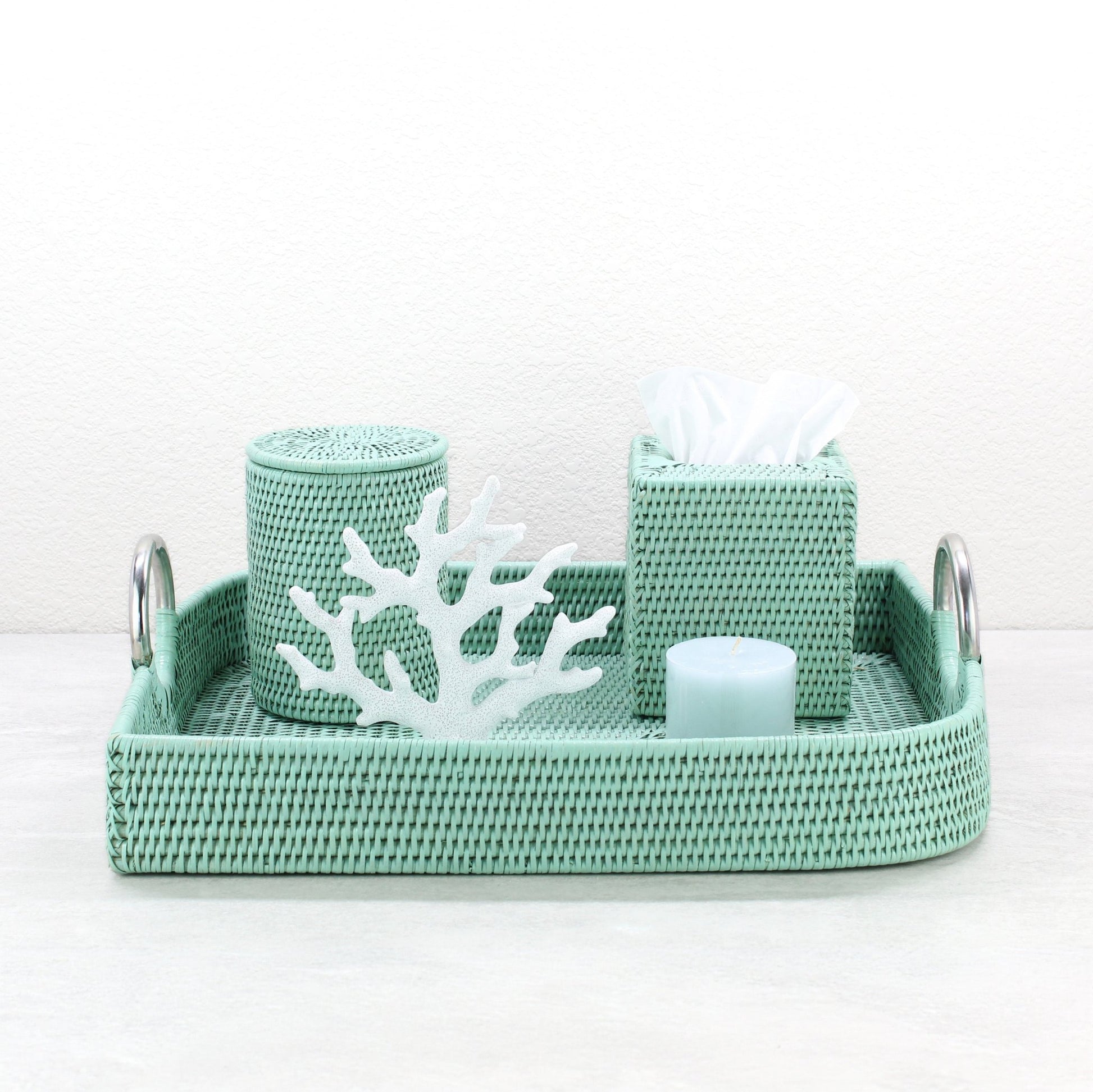 Medium leaf shaped sage leaf green rattan tray with tissue box, round canister, candle, and white coral accent for bathroom decor.