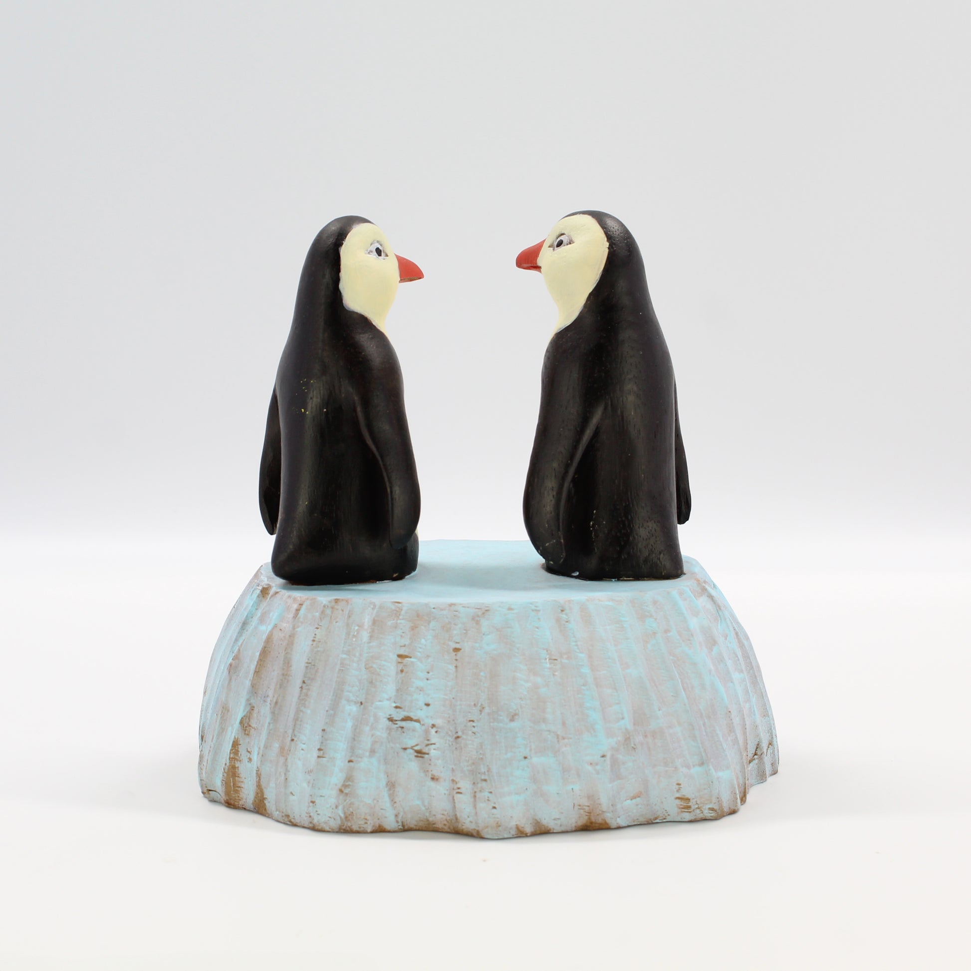Back view of two hand-painted wooden penguin figurines, sustainably carved and eco-friendly holiday or wedding décor