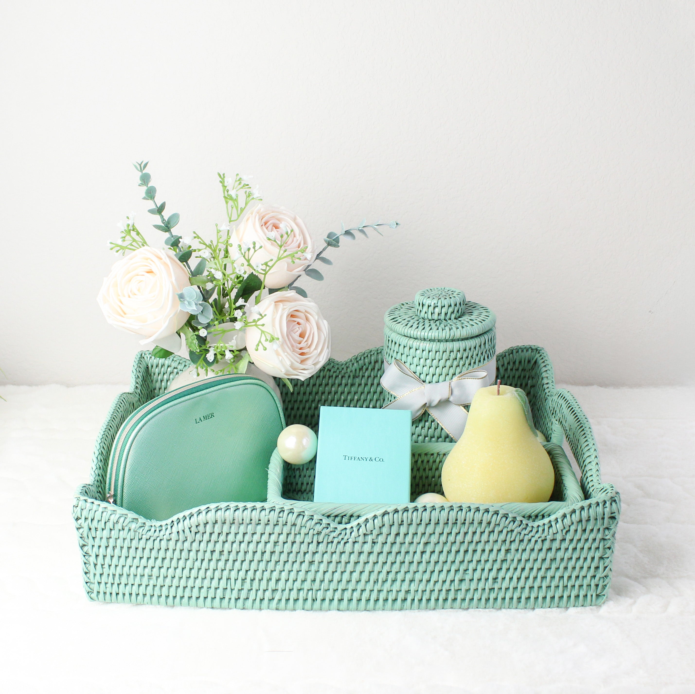 Handmade sage green rattan tray styled as an elegant gift with roses, canister, and luxury accessories for wedding or holiday décor