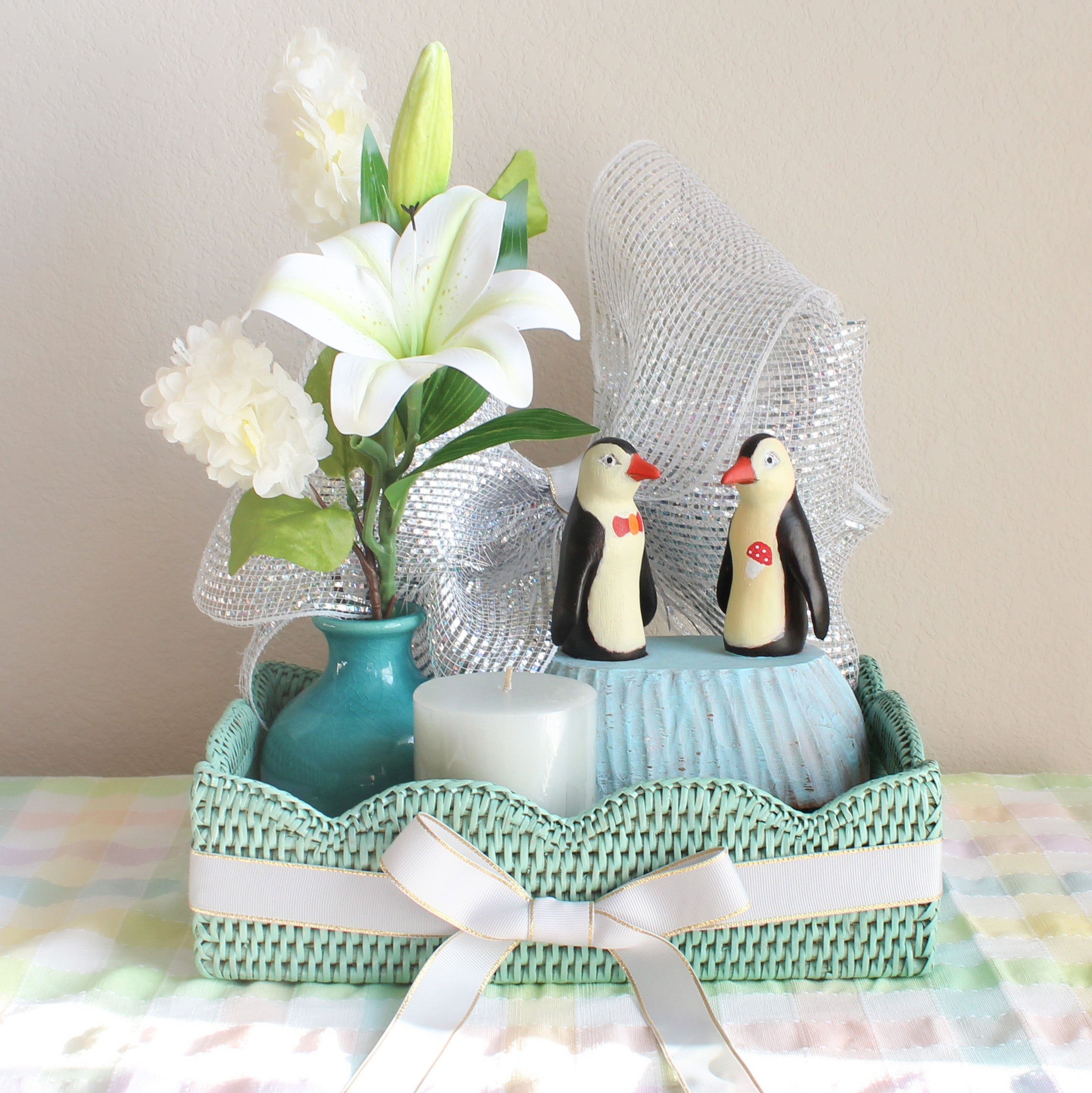 Eco Handcraft sage leaf rattan tray with grey ribbon, penguin figurines, white flowers, vase, and candle décor