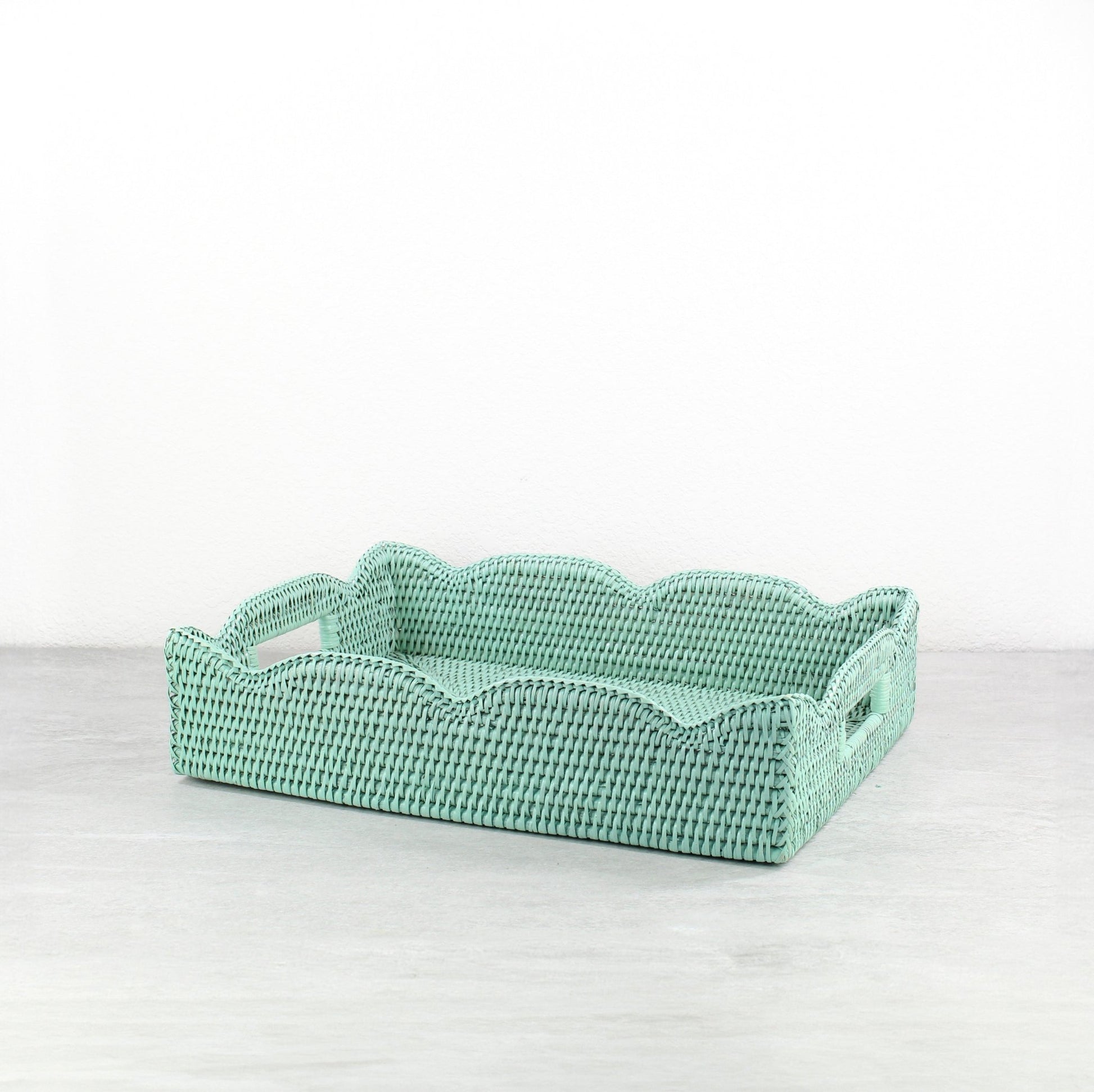 Sage leaf green medium scalloped rattan tray with handles on a white background, showing handwoven detail.
