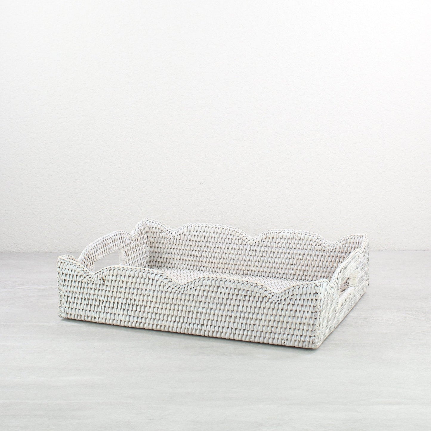 Whitewash medium scalloped rattan tray with handles on a white background, showing handwoven detail.