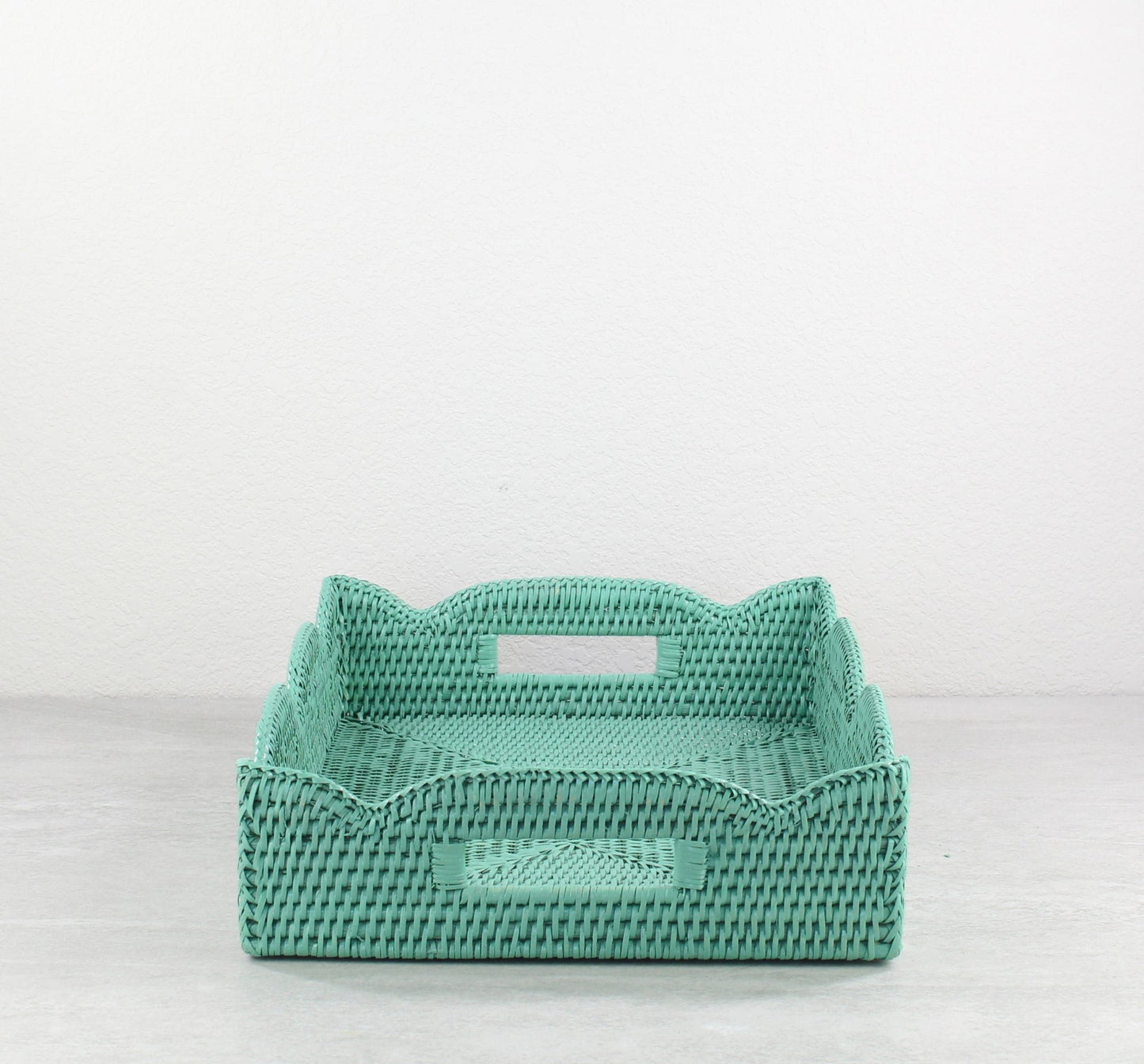 Handwoven turquoise scalloped rattan tray with cutout handles shown on a white background, eco-friendly home decor.