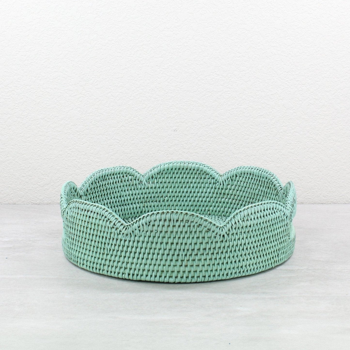 Sage leaf green scalloped round rattan tray handmade from Burmese rattan, shown empty against a neutral background.